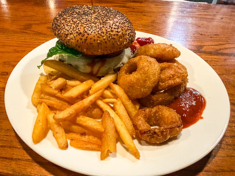 Burger with fries and onion rings at Macarena's Kitchen